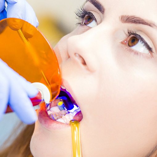 a person receiving dental bonding from a dentist