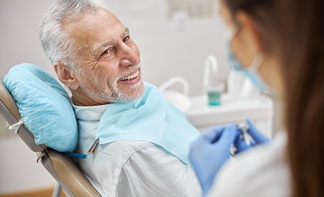 a man speaking with his dentist about getting dentures