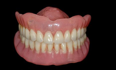 full dentures against a black background