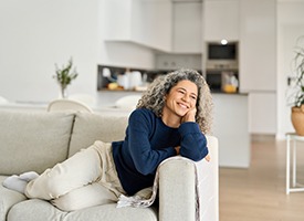 a woman leaning against the arm of a soft